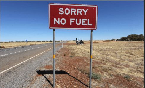 Cartell que indica "Sorry, No Fuel" al costat d'una carretera en un paisatge sec i semiárid.